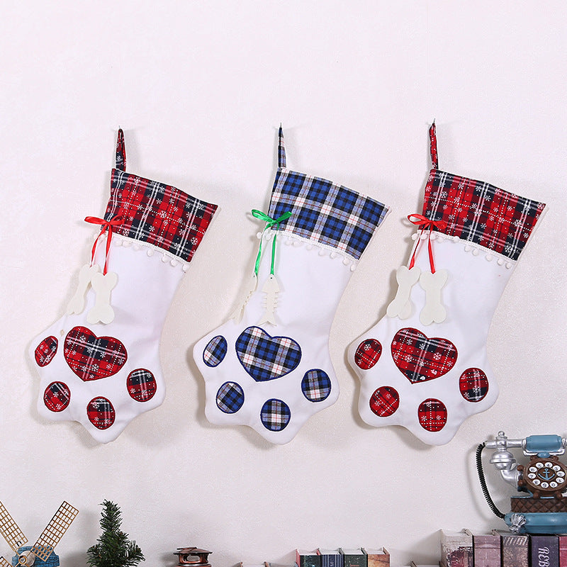 Three plaid Christmas stockings with paw prints on a white background