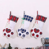 Three plaid Christmas stockings with paw prints on a white background