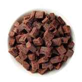 White bowl filled with small brown cubes on a white background