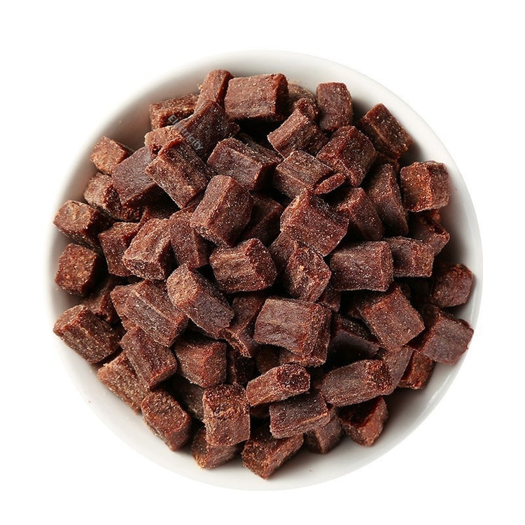 White bowl filled with small brown cubes on a white background