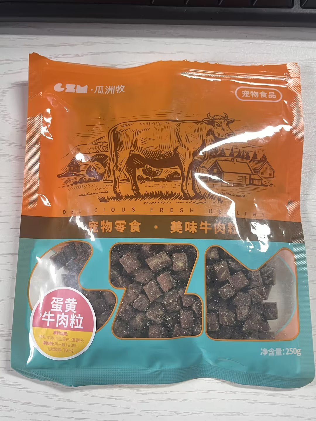 Package of pet food with a cow illustration on an orange and blue background