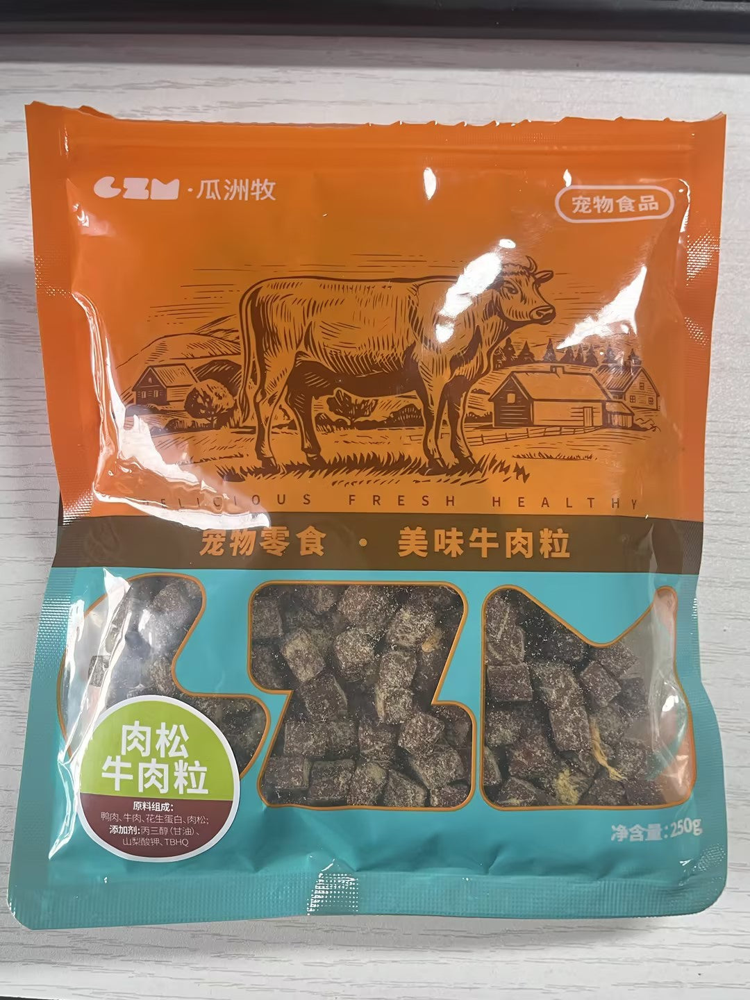 Package of pet food with a cow illustration on an orange background