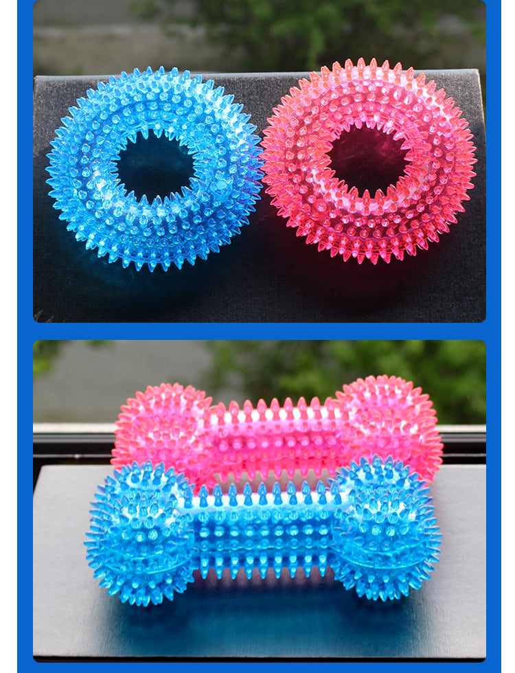 Two blue and pink textured balls on a black surface with a blurred green background.